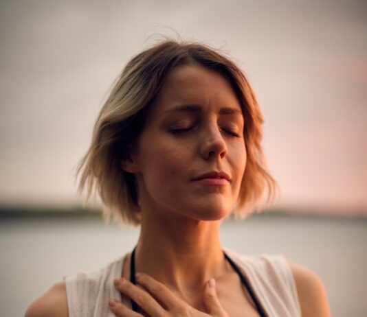 평온과 조화를 찾는 자, 명상의 힘 woman in white vest and black bikini with hand on chest