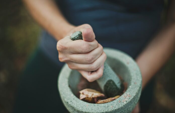 Photo by Katherine Hanlon person grinding on mortar and pestle