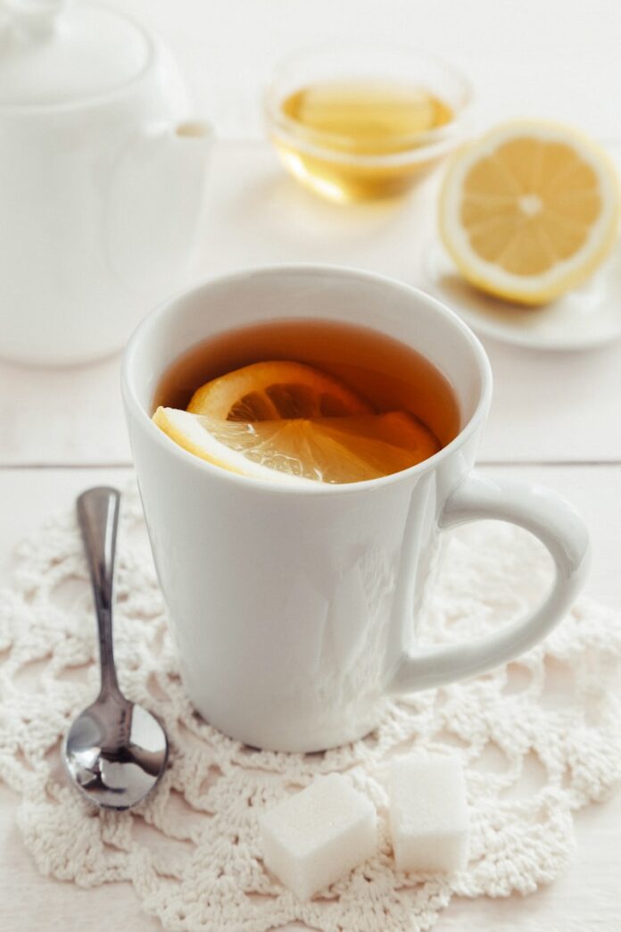 Photo by Elena Leya a cup of tea with a slice of lemon on a doily