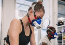 “근육 건강, 일상 속 작지만 강한 변화로 챙긴다” a woman wearing a gas mask while riding a stationary bike