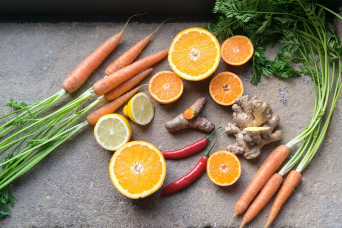 Photo by Josh Millgate sliced orange fruit beside green and orange vegetable