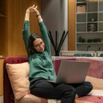 하루 10분, 똑똑하게 몸을 깨우는 ‘마이크로 운동’ 열풍 a woman sitting on a couch using a laptop