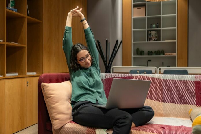 Photo by Resume Genius a woman sitting on a couch using a laptop