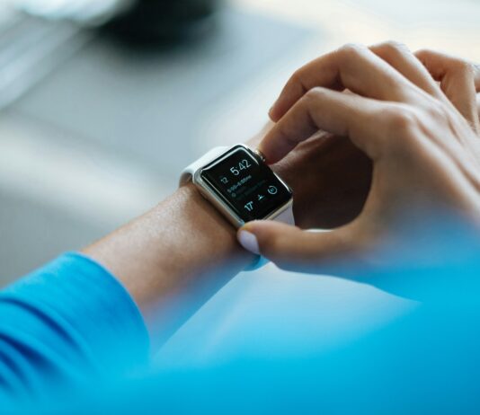 “웨어러블 데이터가 주도하는 건강관리 혁명: 손목에서 시작되는 일상 속 건강 비결” person clicking Apple Watch smartwatch
